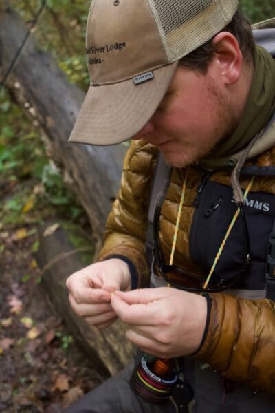 Fly fisherman tying a know in fly line.
